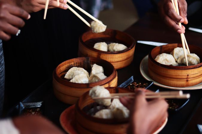 People eating dumplings with chopsticks