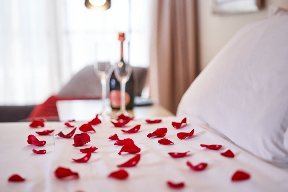 Bed with bedclothes covered with rose petals
