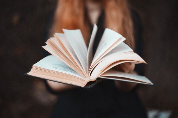 Close-up shot of woman holding an open book