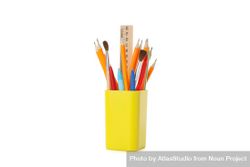 Yellow pencil holder filled with pencils, pens and ruler 5rJxn5