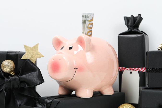 Piggy bank with cash and gift boxes on light background, close up