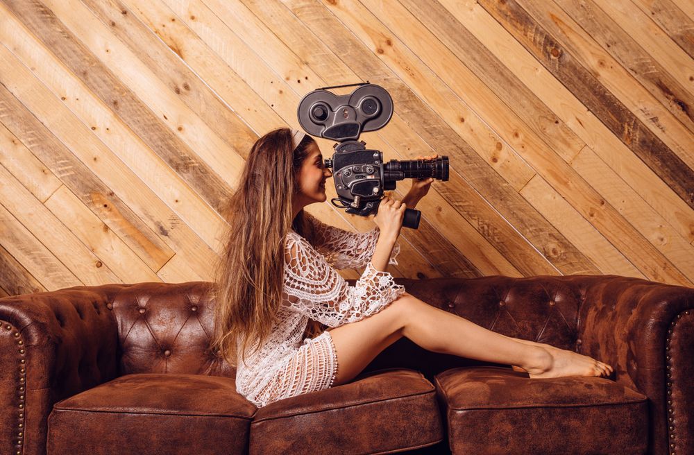 Young woman recording video with a vintage camera
