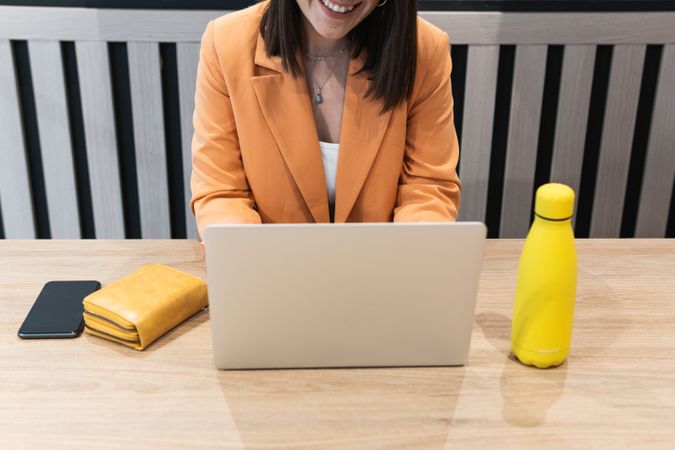 Crop woman sitting at a table and working with computer