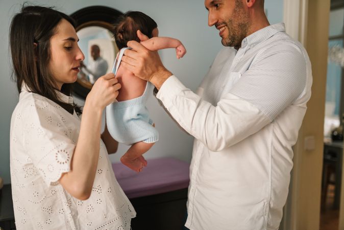 Parents putting pants on baby