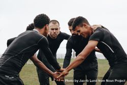 Soccer players joining hands in huddle talking about the game strategy 5XpKG5