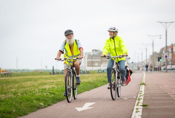 Mature man and woman enjoying biking along the coast