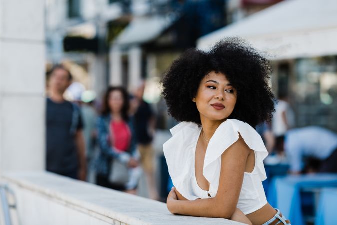 Black female leaning in concrete parapet