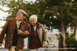 Portrait of couple with gray hair and winter clothes talking and walking outdoors on winter day 4ZkOrb