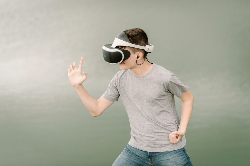 Young teenager with virtual reality glasses outdoors