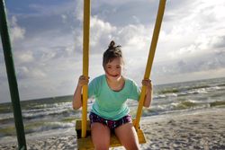 Young child having fun outdoors on swing set