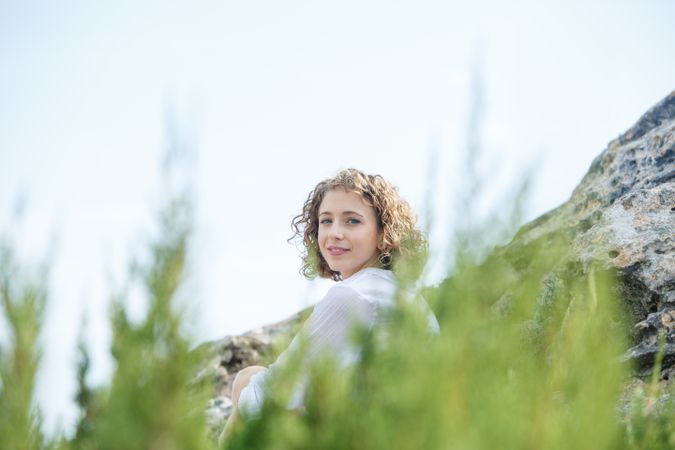 Young woman sitting between stones and branches