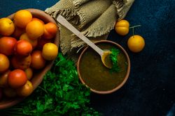 Bowl of plums with parsley with Georgian Tkemali Sauce