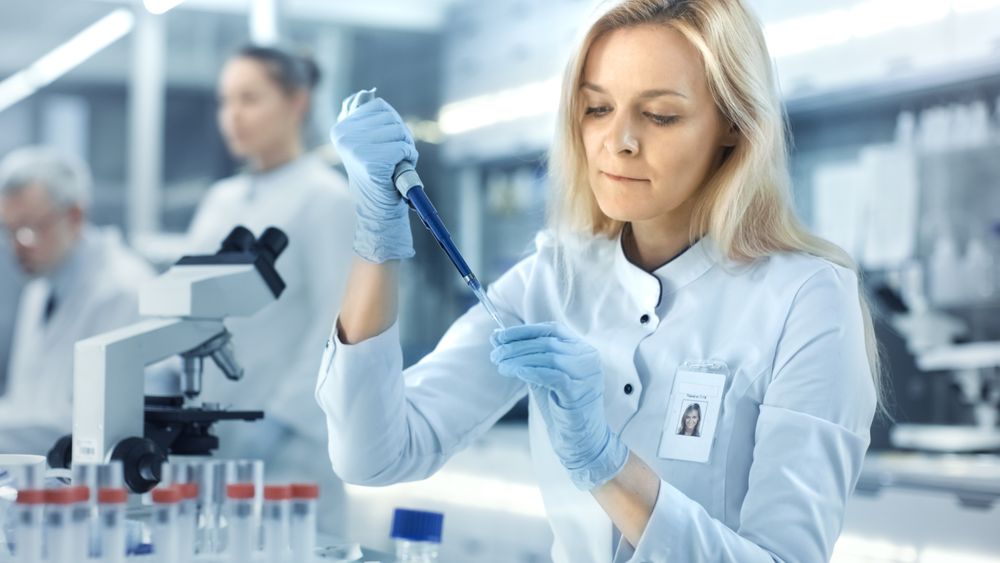 Female Research Scientist Uses Micropipette Filling Test Tubes.