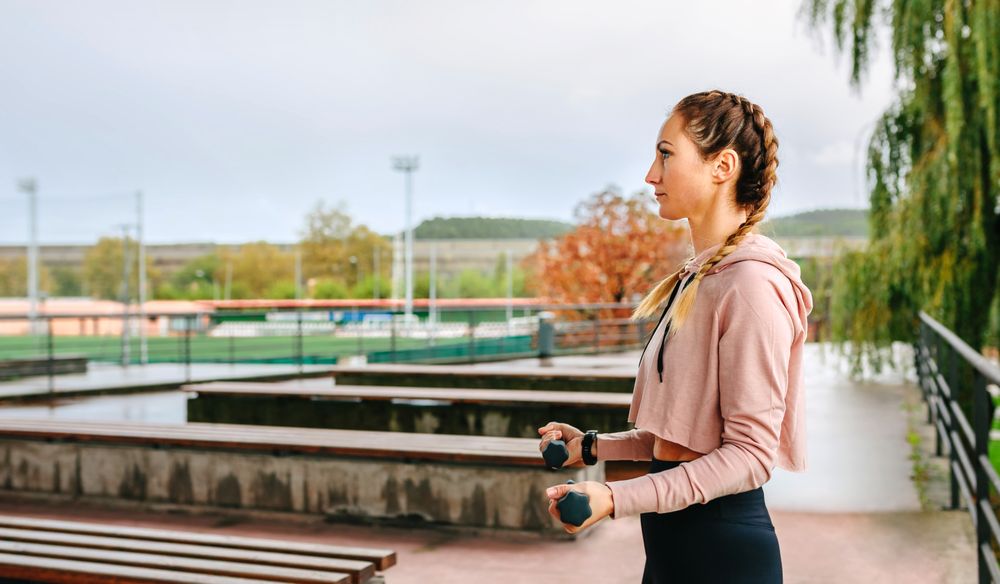 Young woman training with dumbbells