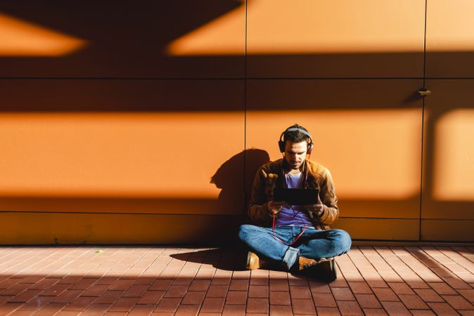 Man using tablet and headphones in modern building