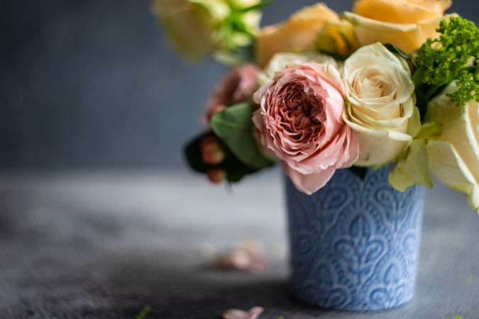 Vase of pastel roses in grey shoot