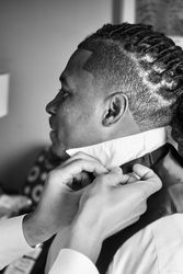 Grayscale photo of groom getting ready for wedding