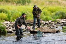 Fishermen Catching Fish Together on River