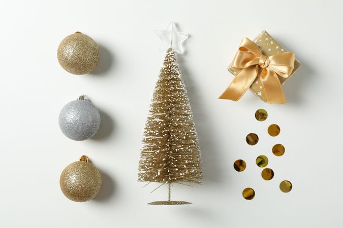 Flat lay with christmas balls, tree, present and confetti on plain background, space for text