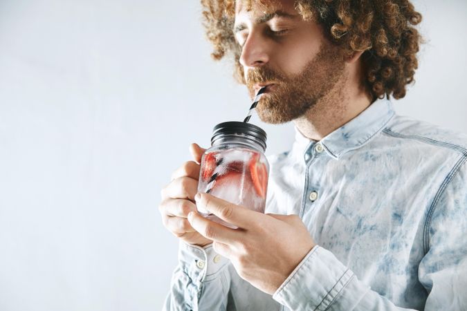 Man drinking strawberry infused water