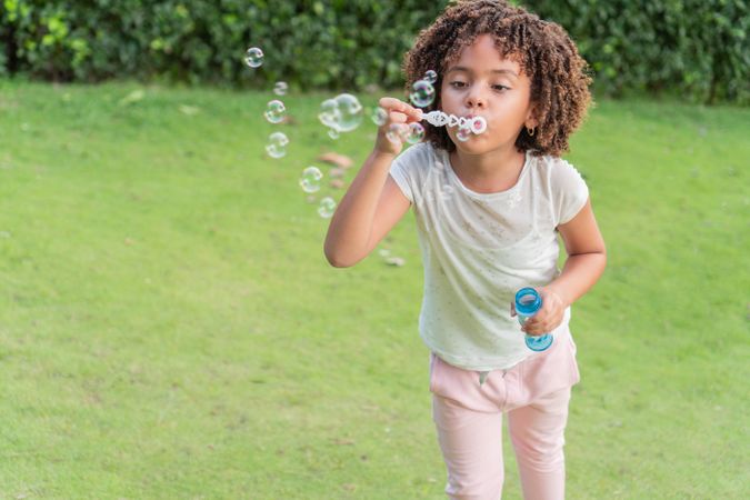 Girl blowing soap bubbles in the open air