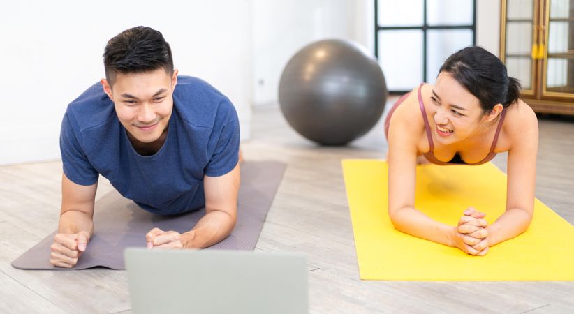 Happy Asian couple planking exercise on yoga mat together