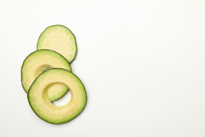 Ripe fresh avocado slices on plain background
