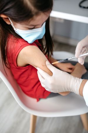 Girl receiving coronavirus vaccine at doctor's office