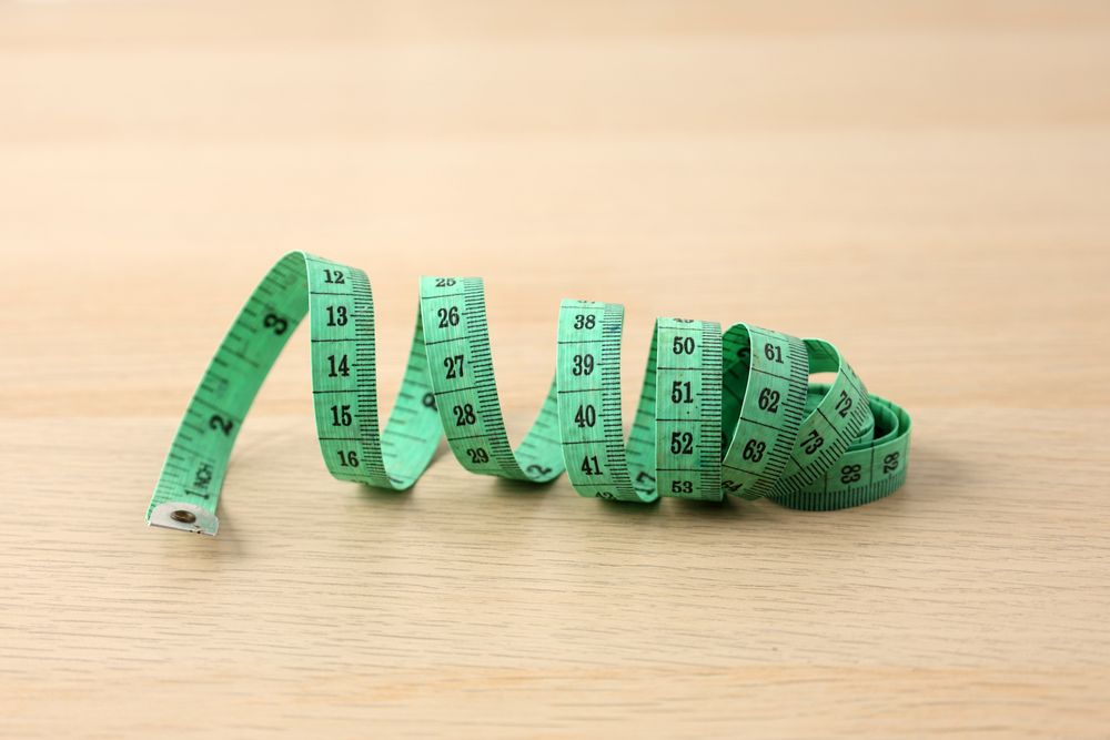 Green Measuring Tape on Wooden Table