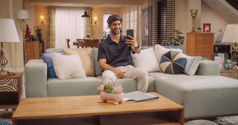 Indian Man Using Smartphone while on Video Call at Home, Doing Remote Work