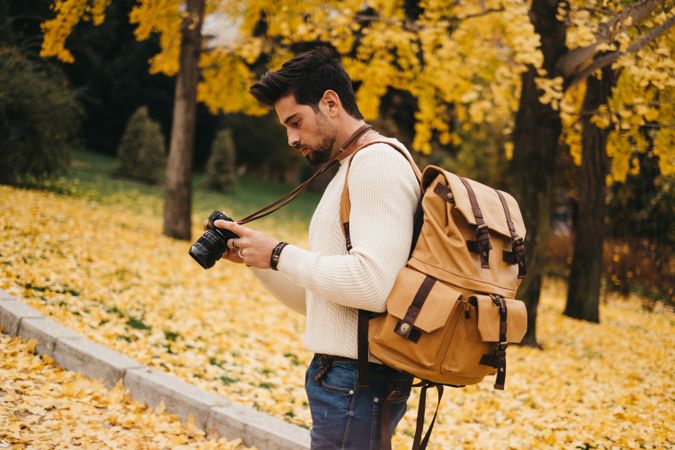 Trendy male with backpack and camera
