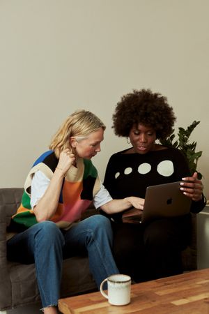 Two women reviewing reports on laptop