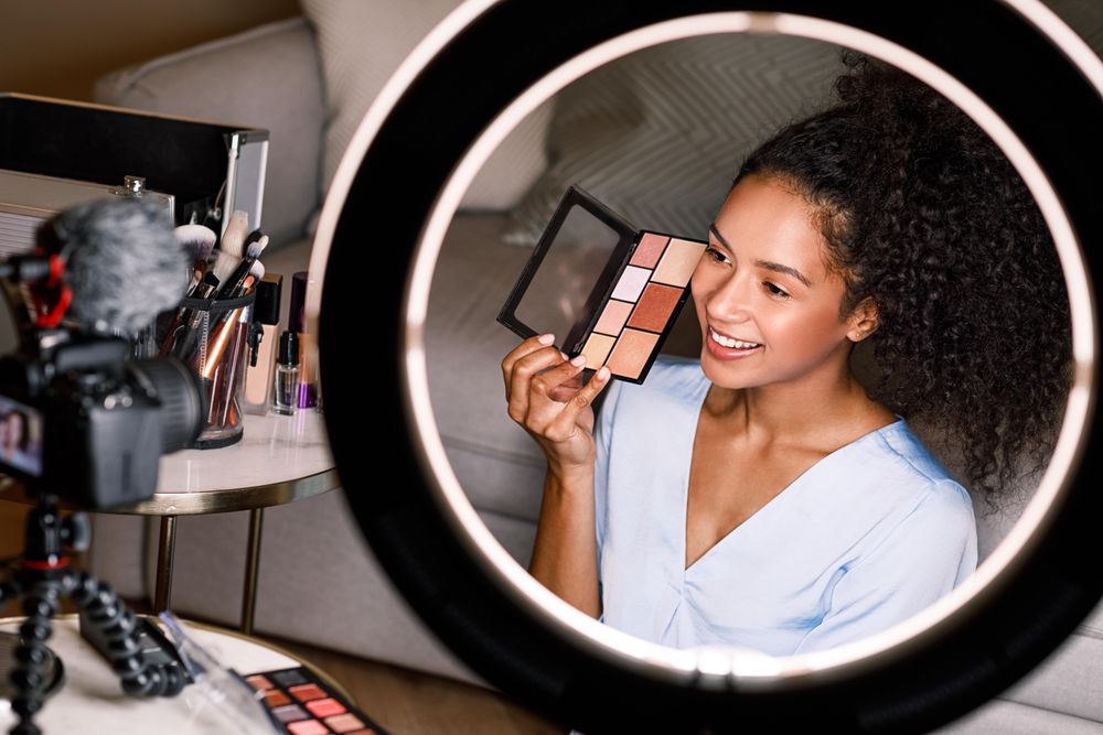Woman pictured using light ring holding up a make up palette