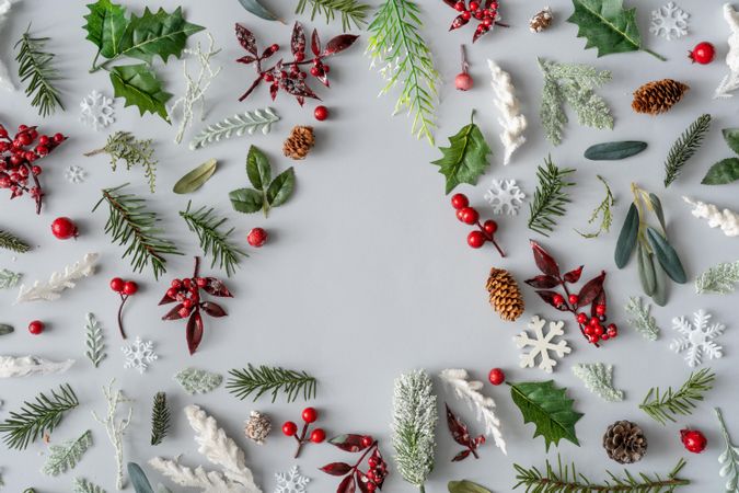 Assortment of holiday branches, berries and pinecones creating a tree of negative space