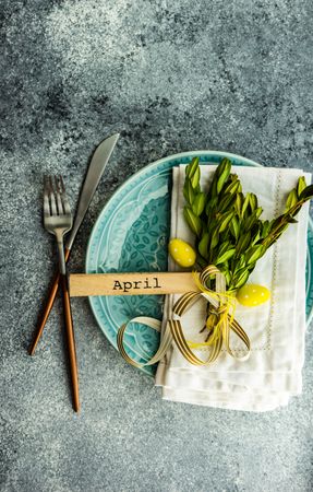 Easter card concept of branch and yellow mini eggs on table setting