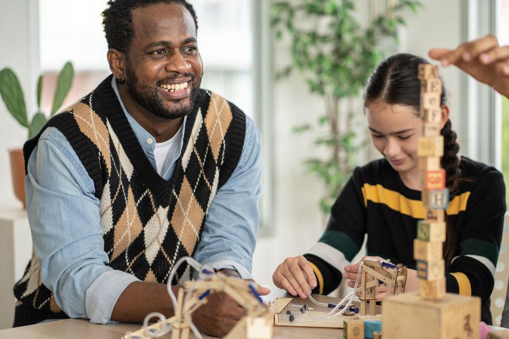 Male teacher working with wooden blocks in his classroom