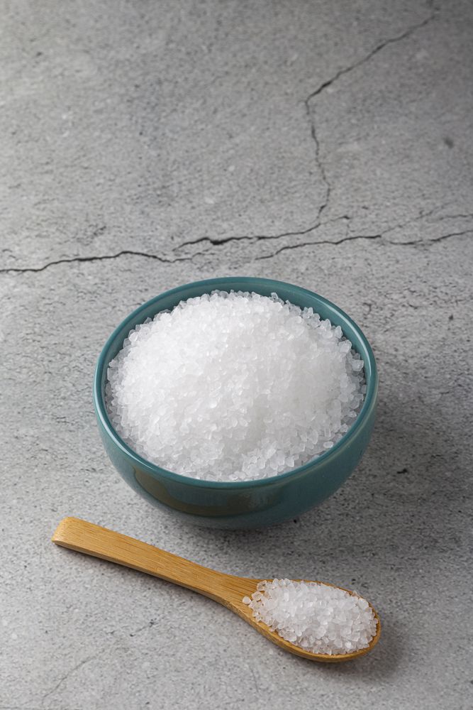Bowl with coarse salt on the table.