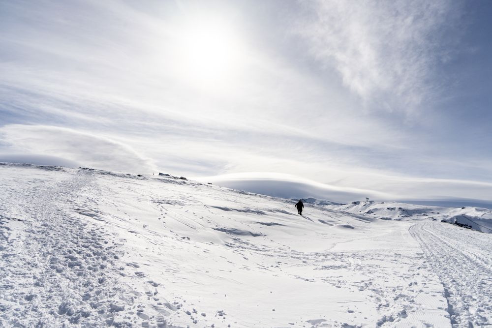 Person walking in distance of ski resort of Sierra Nevada in winter
