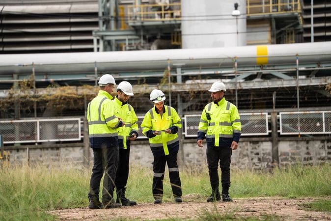 Group of engineer workers checking project at refinery oil factory