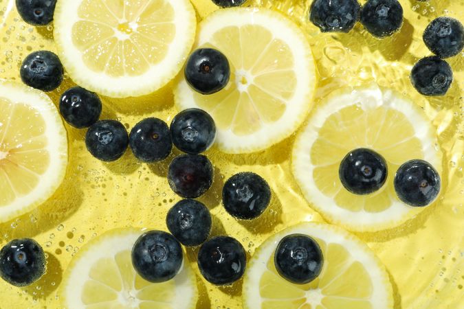 Top view of blueberries and lemons soaking in water