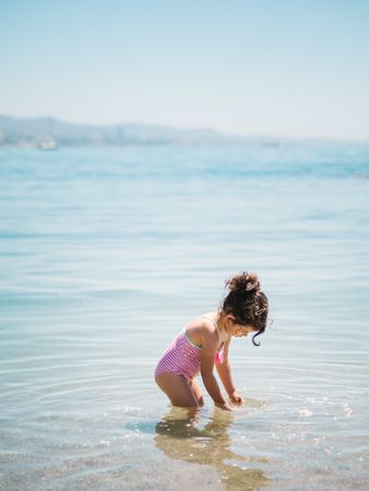 Cute girl playing in water of seaside
