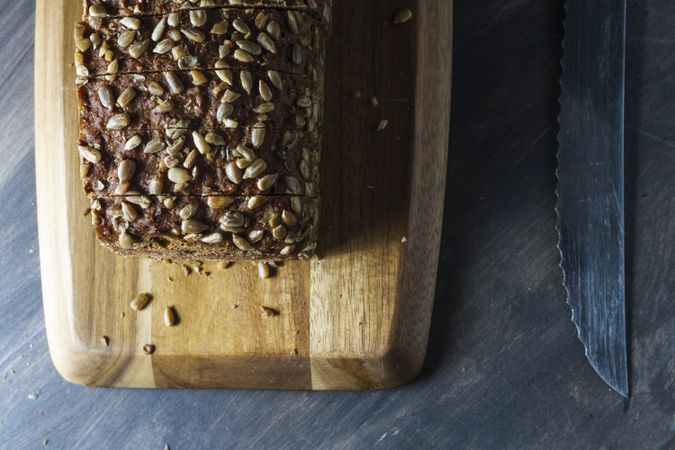 Sliced wholegrain bread on wooden cutting board