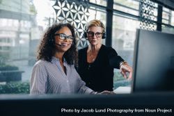 Manager helping female colleague working on computer 0W9v14