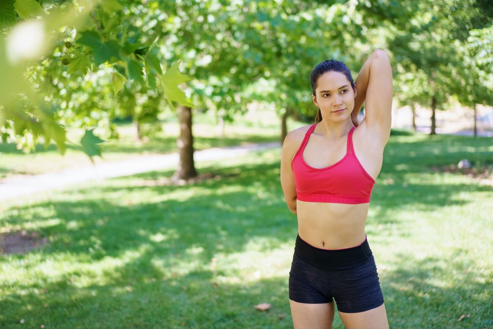 Woman stretching triceps in park