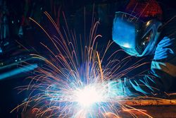 Person with welding shield using the machine