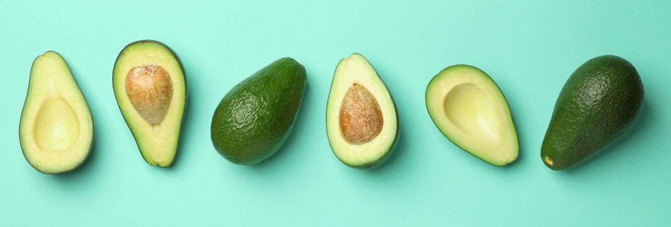 Ripe fresh avocado on mint background, top view