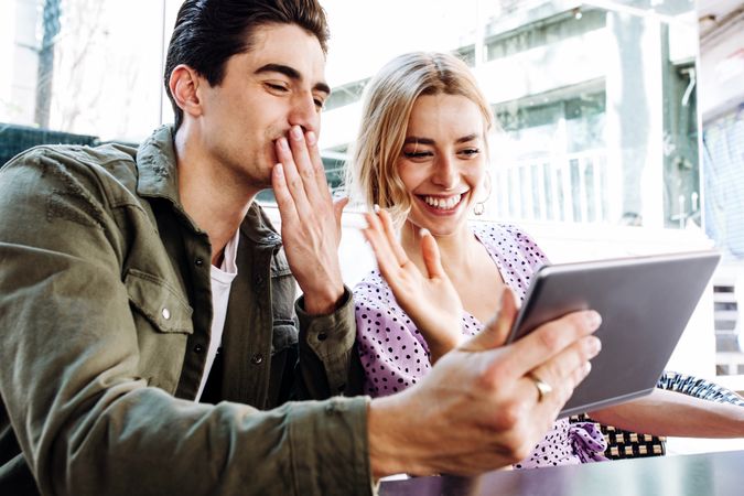 Happy young couple using tablet outdoors