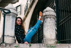 Young woman sitting between pillars on street