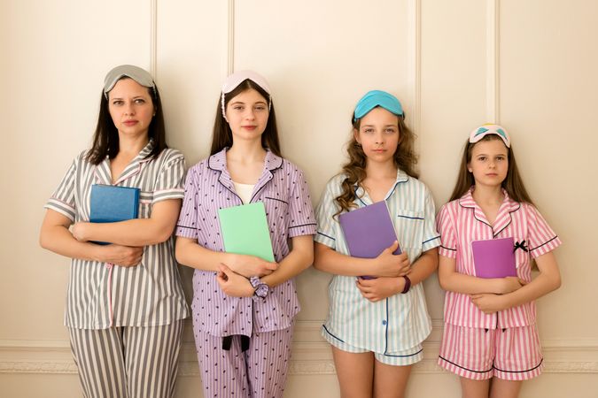 Woman and group girls in striped pajamas holding books