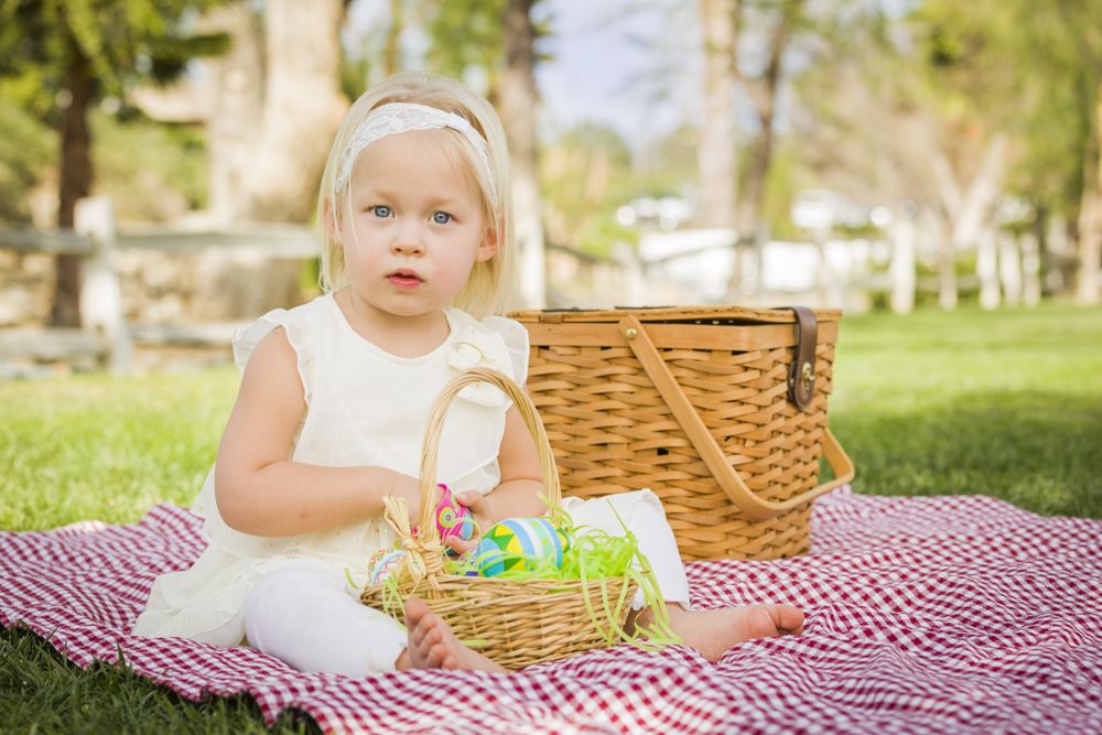 Cute Baby Girl Enjoying Her Easter Eggs on Picnic Blanket